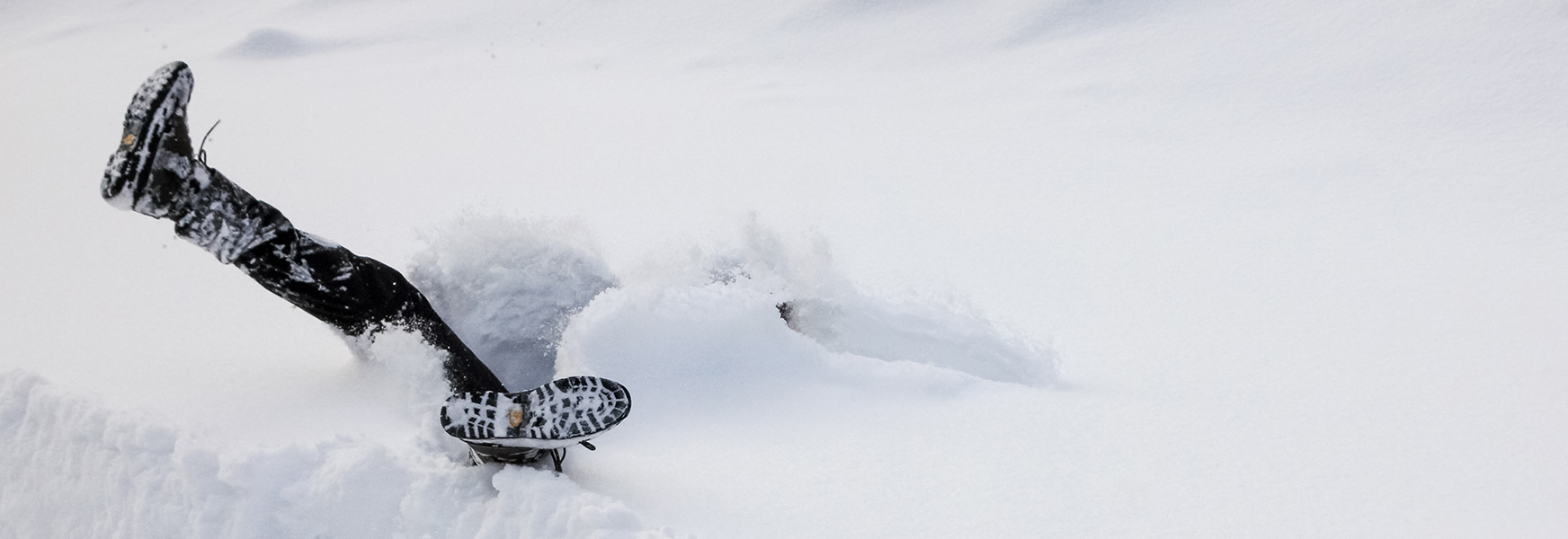 Person in snowbank with boots sticking up
