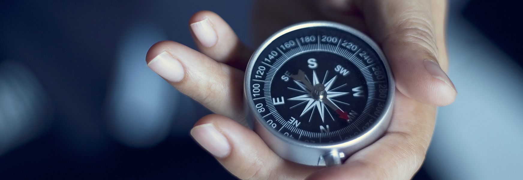 Hand holding a compass