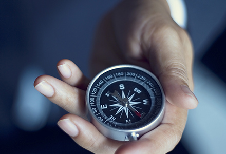 Hand holding a compass