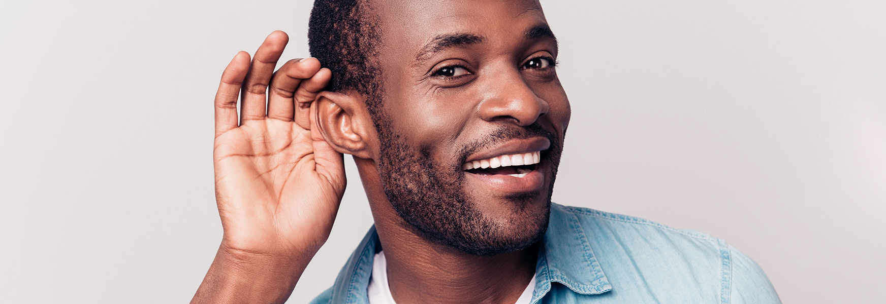 man with hand at ear listening