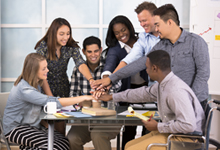 group of employees putting in a hand for team building 