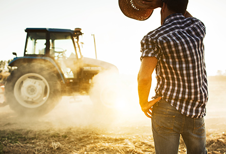 Man with tractor working in the hot sun