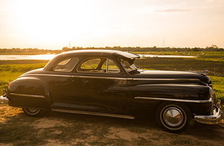 Vintage Automobile In Green Field At Dusk