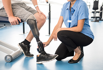 Medical professional assists patient with prosthetic leg