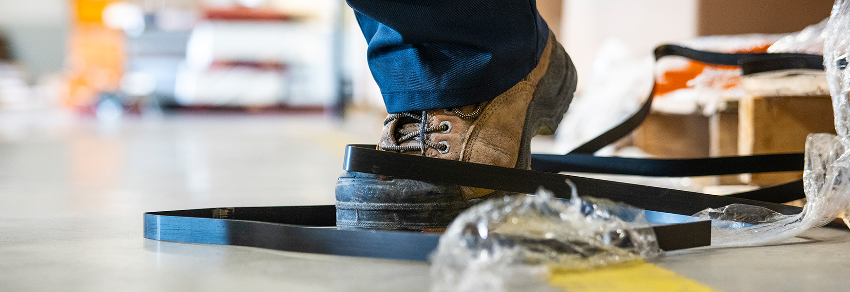 Factory worker's boot tripping over trash