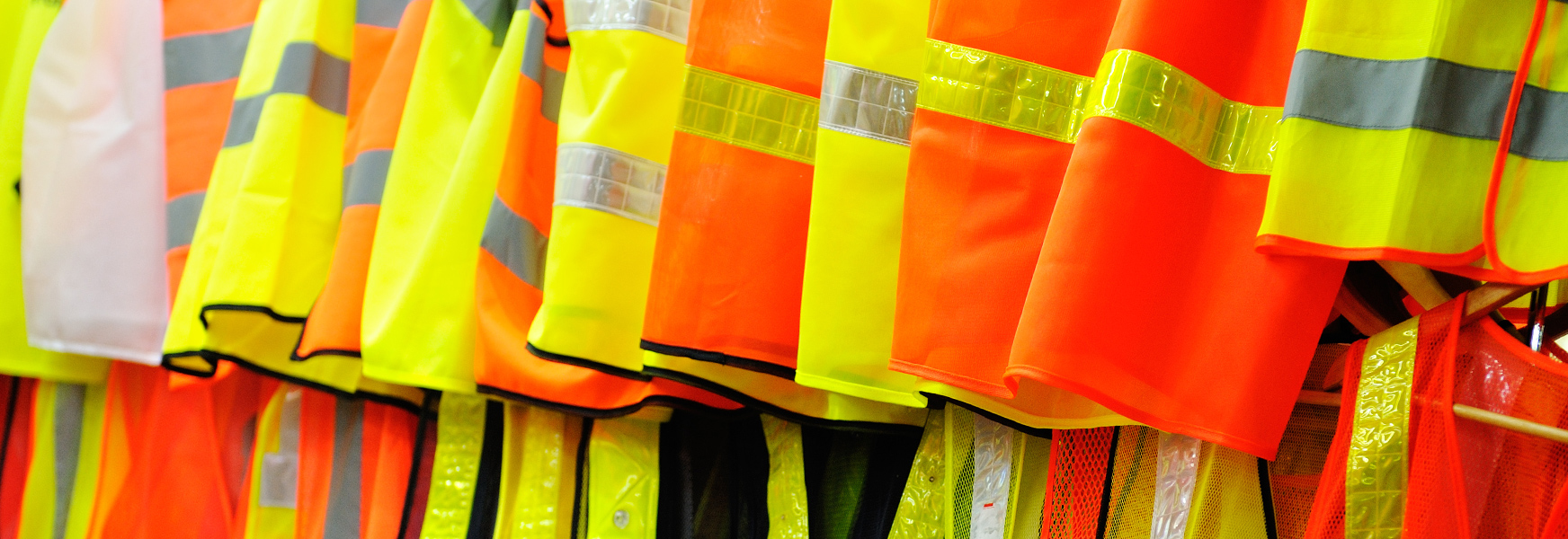 Orange and yellow safety vests hanging on a rack