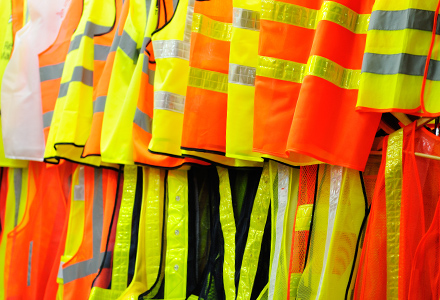 Orange and yellow safety vests hanging on a rack