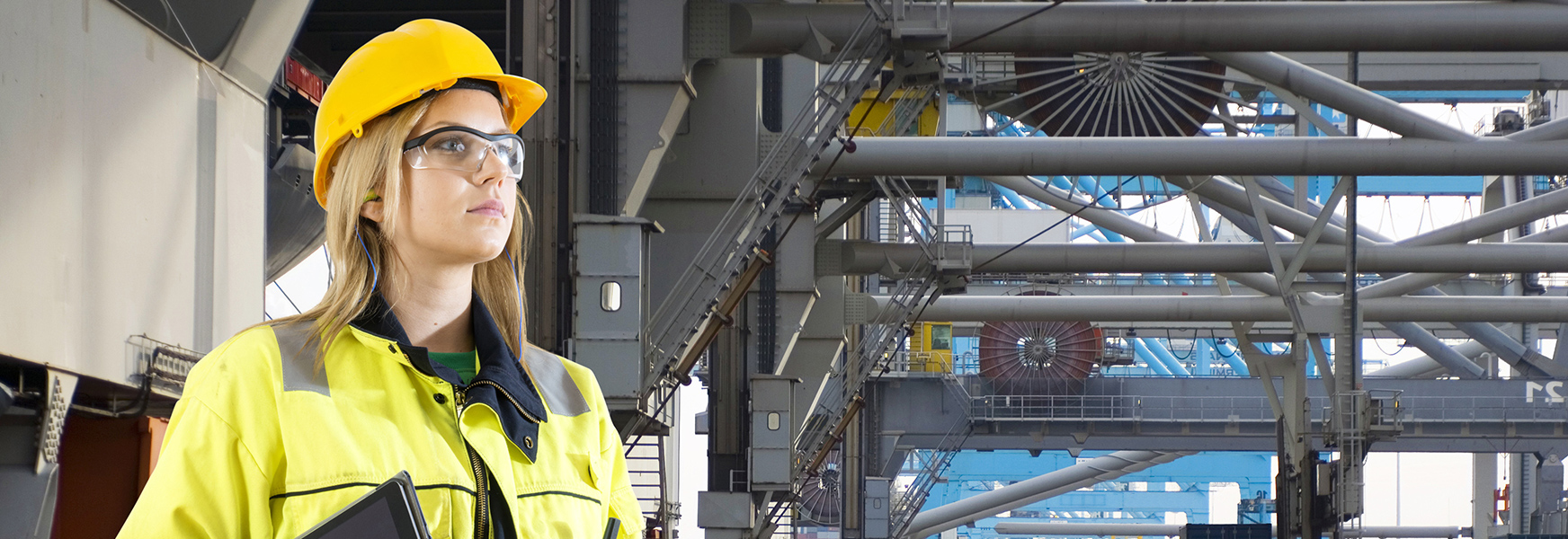 Woman wearing hard hat and personal protective equipment standing in a factory