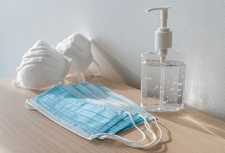 Masks and hand sanitizer on table