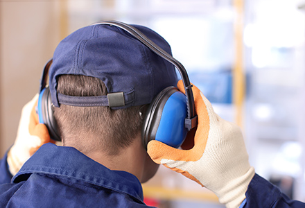 Factory worker applying ear protection