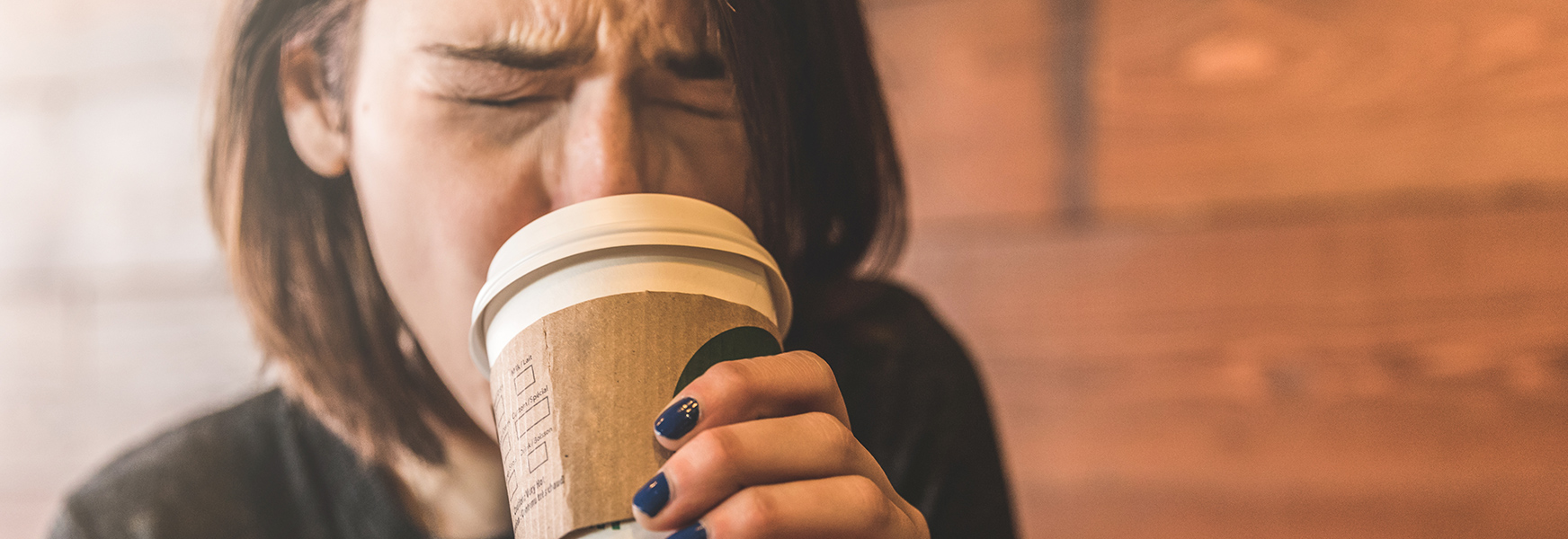 Woman sipping hot coffee and burning her mouth