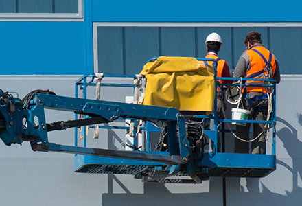 Two workers working in a boom lift.