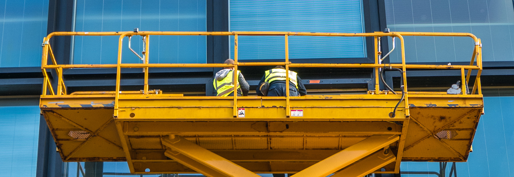Workers in elevated work platform cleaning windows