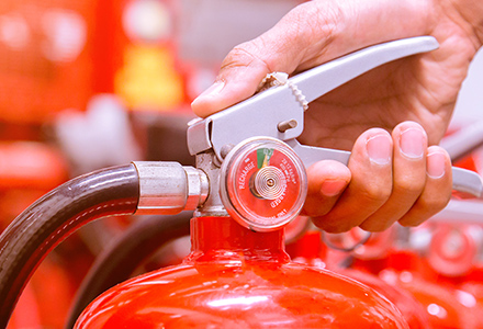 Hand holding a fire extinguisher