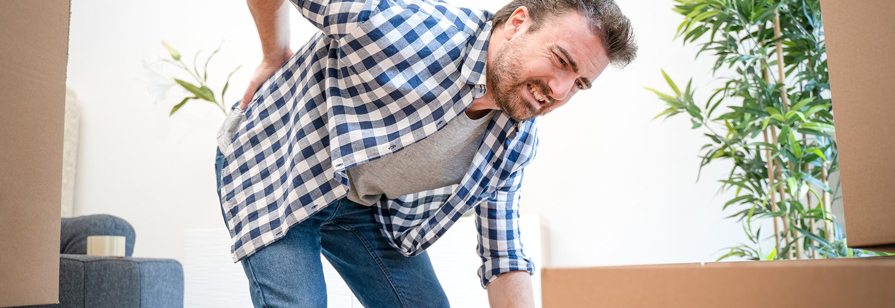 Man with sore back from improper lifting technique