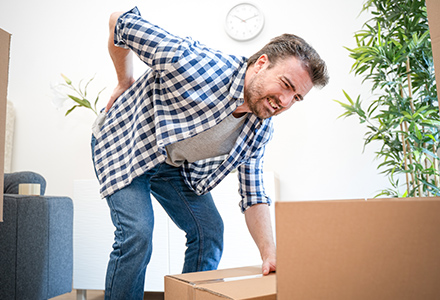 Man with sore back from improper lifting technique