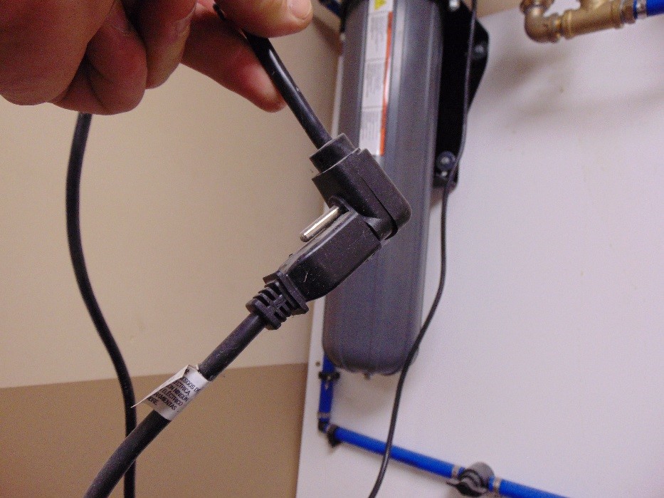 Grounding hazard. Three-pronged electrical plug inserted into two-pronged extension cord