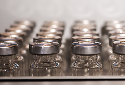 Empty vaccine bottles exiting production line