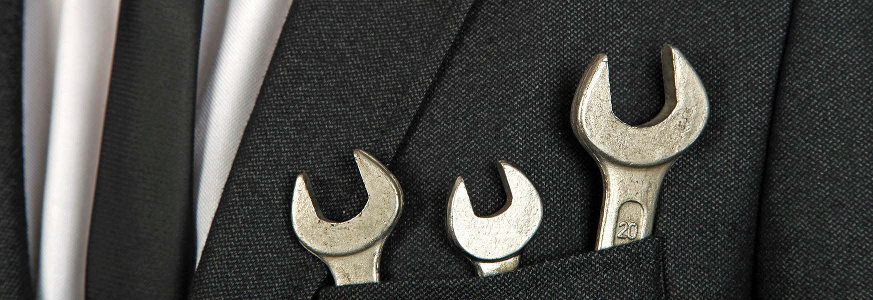 Wrenches in businessman's suit jacket pocket