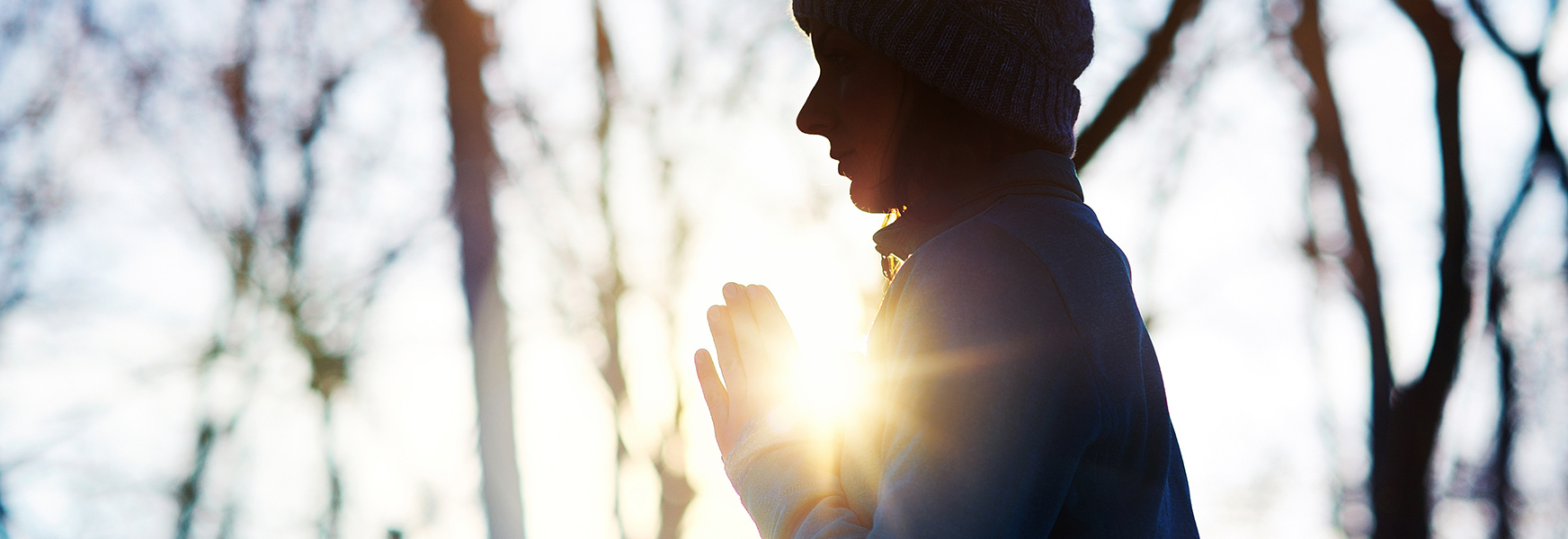 Young woman meditating outside during winter