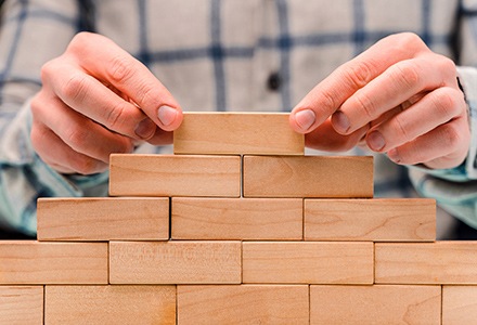 Hands stacking wooden blocks