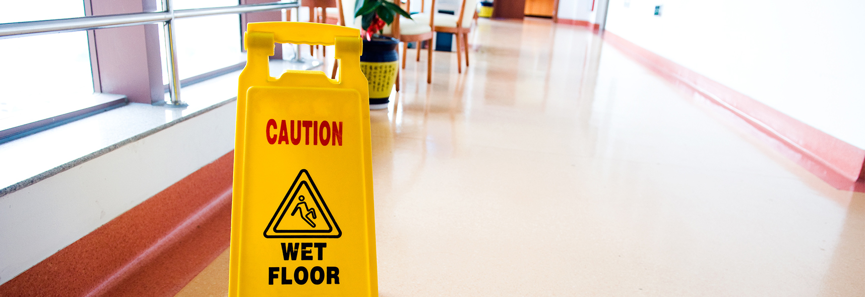Wet floor sign standing in business hallway
