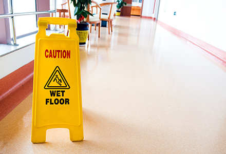 Wet floor sign standing in business hallway