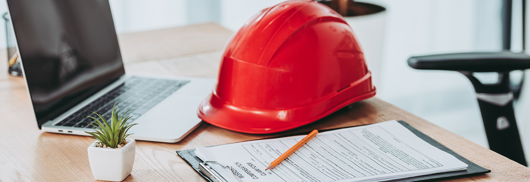 Hardhat and office supplies laying on office desk