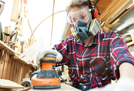 Young woman wearing PPE while working on DIY project at home