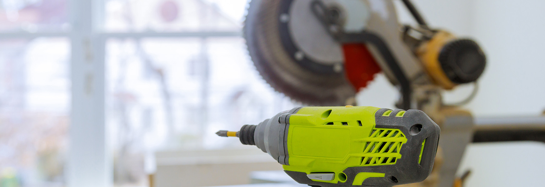 Power drill and circular saw on workbench