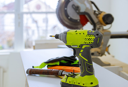 Power drill and circular saw on workbench