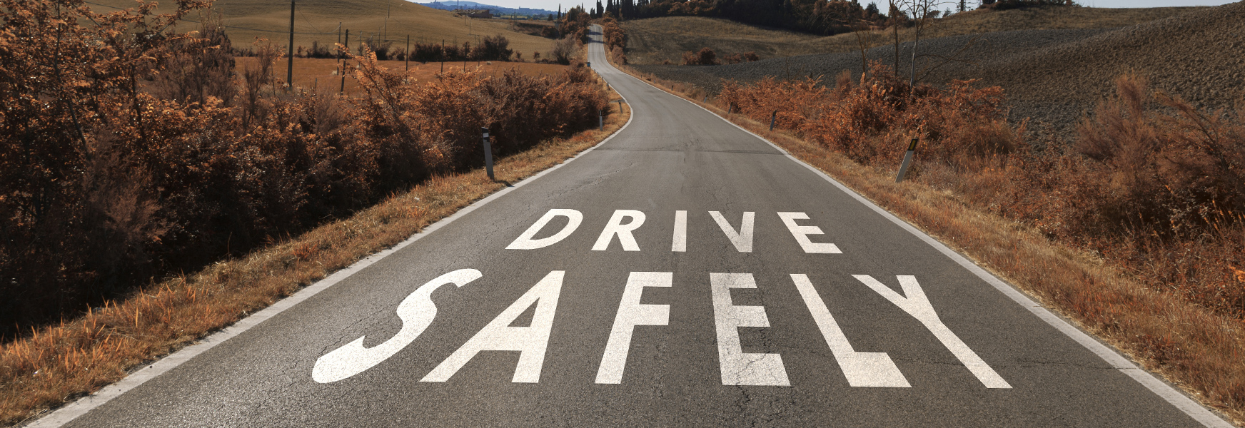 Drive Safely written across rural road
