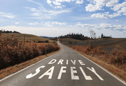 Drive Safely written across rural road