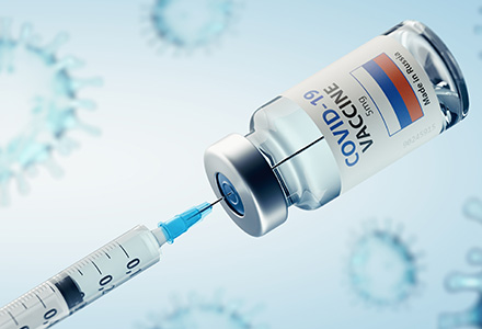 Syringe inserted into Covid19 vaccine bottle.