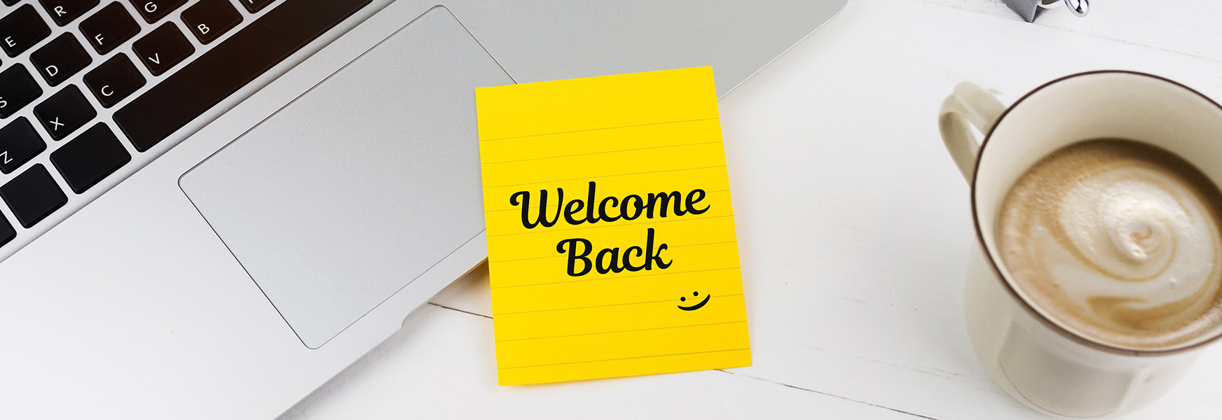 Welcome Back sticky note on office workstation