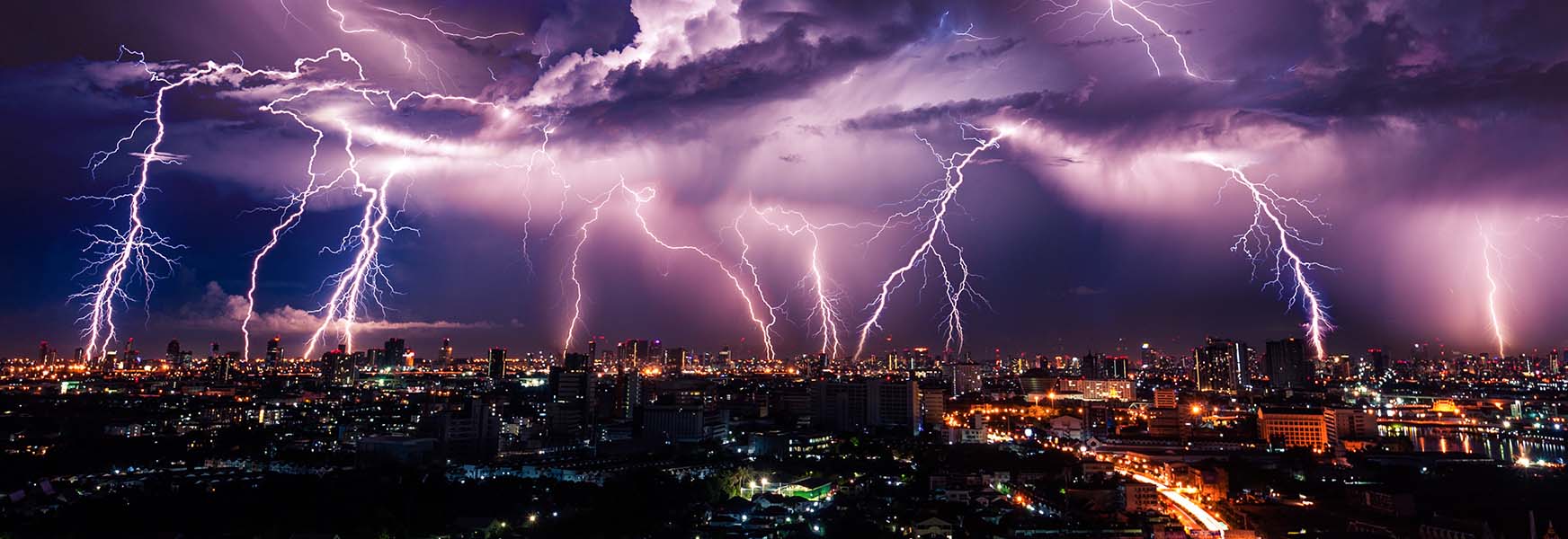 Night time lightning strikes over a big city