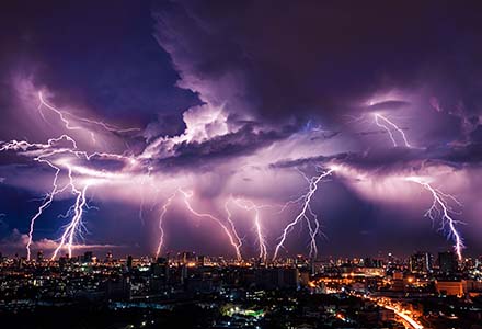 Night time lightning strikes over a big city