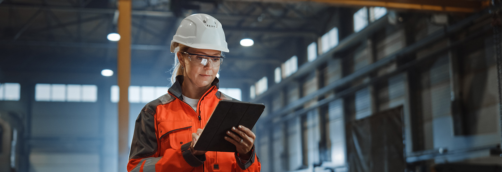 Safety professional wearing PPE and using tablet