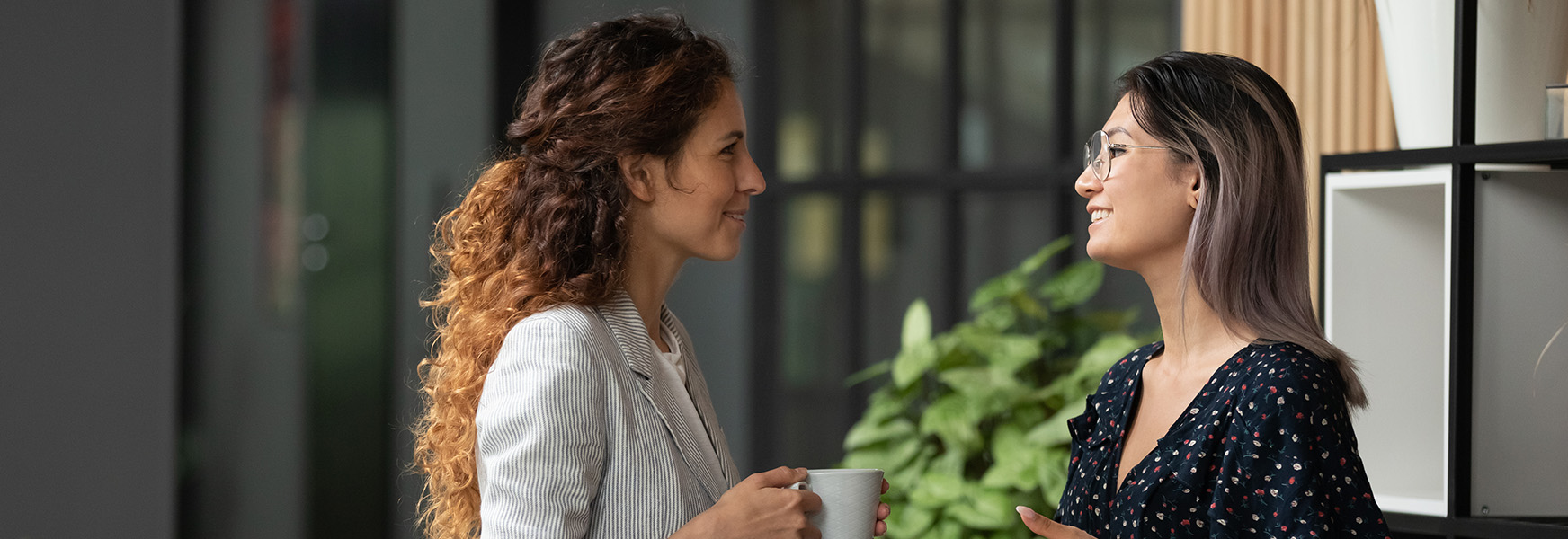 Women smiling and talking in office setting