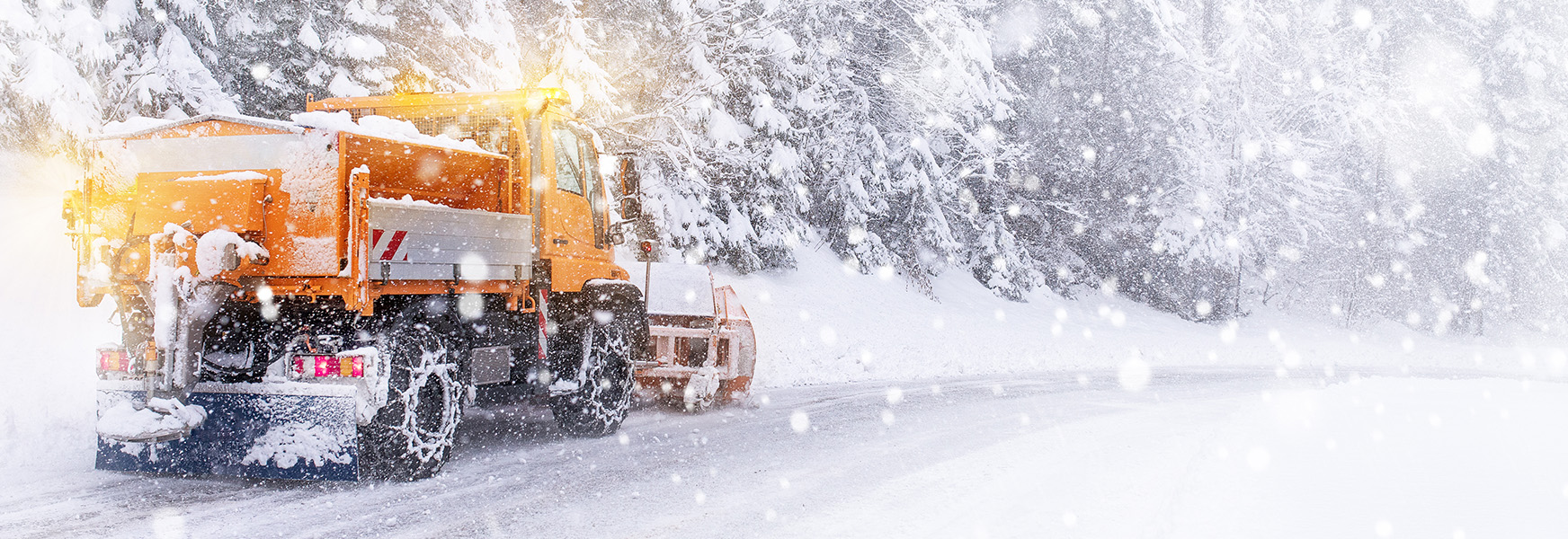Commercial plow truck driving on wintery roads