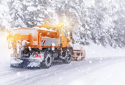 Commercial plow truck driving on wintery roads