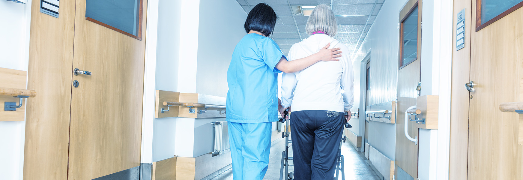 Nurse assisting elderly patient with walking
