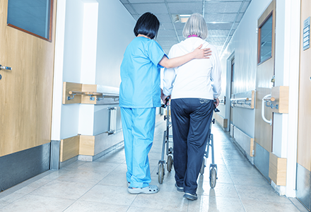 Nurse assisting elderly patient with walking