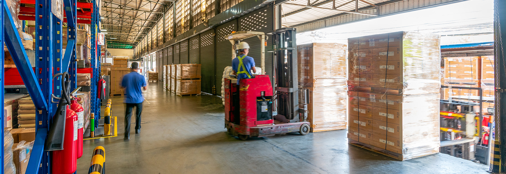 Warehouse worker loading truck with a forklift
