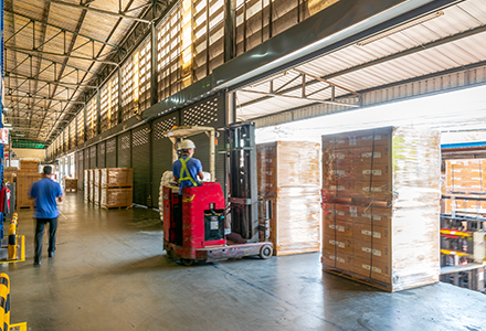 Warehouse worker loading truck with a forklift