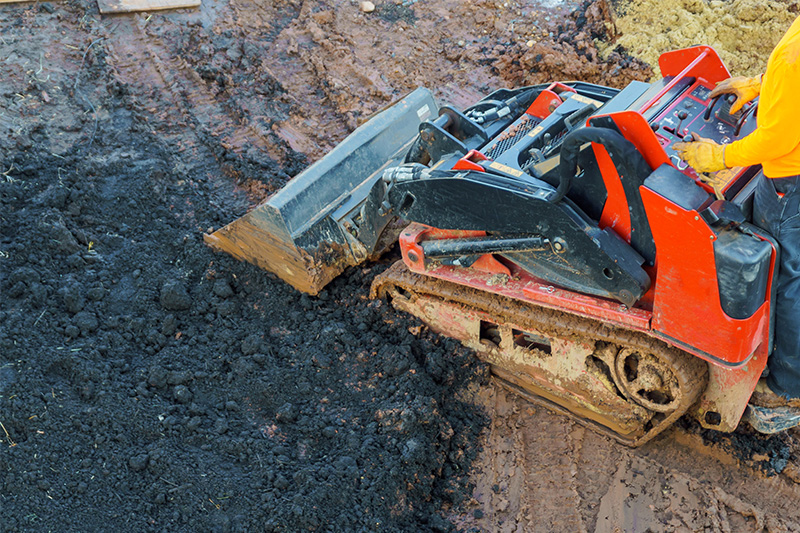 Moving dirt with mini skid steer loader