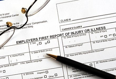 First report of injury form and pen sitting on a desk