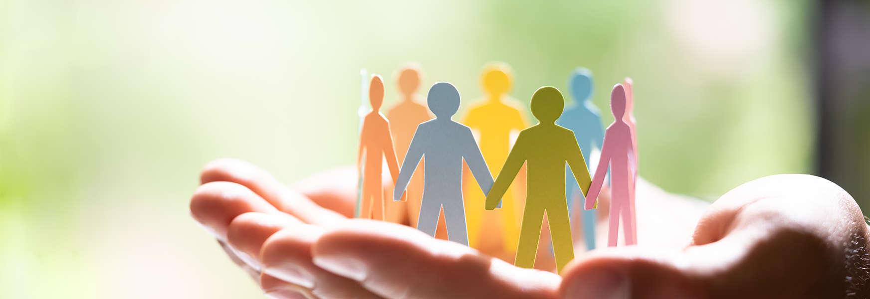 Hand holding papercraft people holding hands in a circle