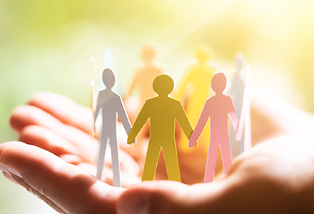 Hand holding papercraft people holding hands in a circle