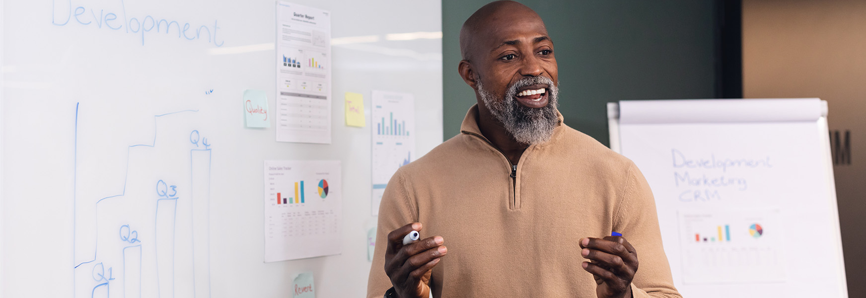 Enthusiastic mature business man presenting charts and data